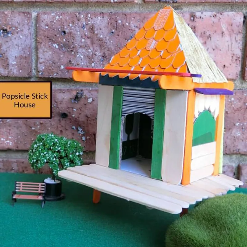 Popsicle stick house with cardboard rooftop